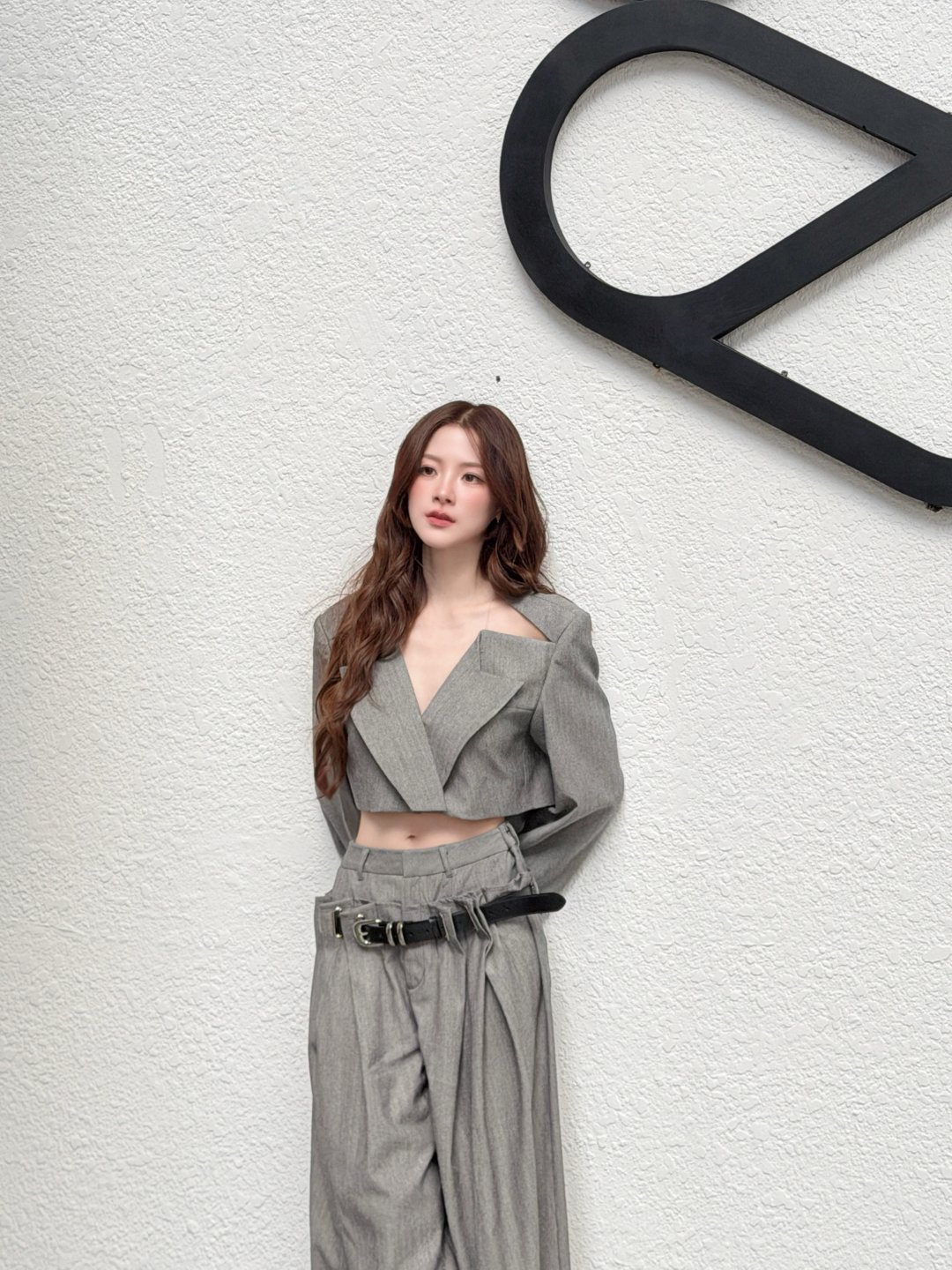 ใบเฟิร์น พิมพ์ชนก เซ็ตสูทครอปสีเทาโชว์เอวคู่กางเกงขากว้าง โพสต์ท่าหน้ากำแพงขาว "🩶😚"