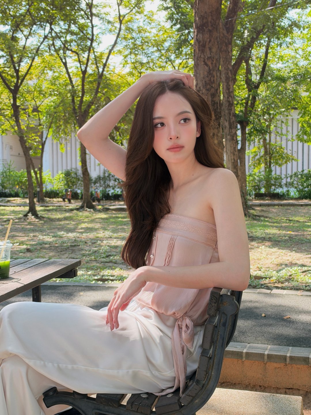 ณิชา ณัฏฐณิชา "My favorite nude shade ever" เกาะอกชมพูนู้ดคู่กางเกงขาว นั่งม้านั่งในสวนถือลิป L’Oréal