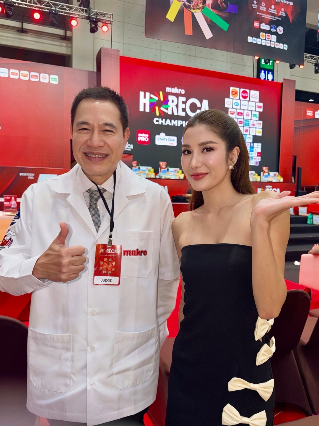 THAMITA ANUSIN เดรสเกาะอกดำผ่าข้างประดับโบว์ขาว ถือไมค์เป็นพิธีกรบูธ McCormick งาน HeReCa 2026 (รูปที่ 3)